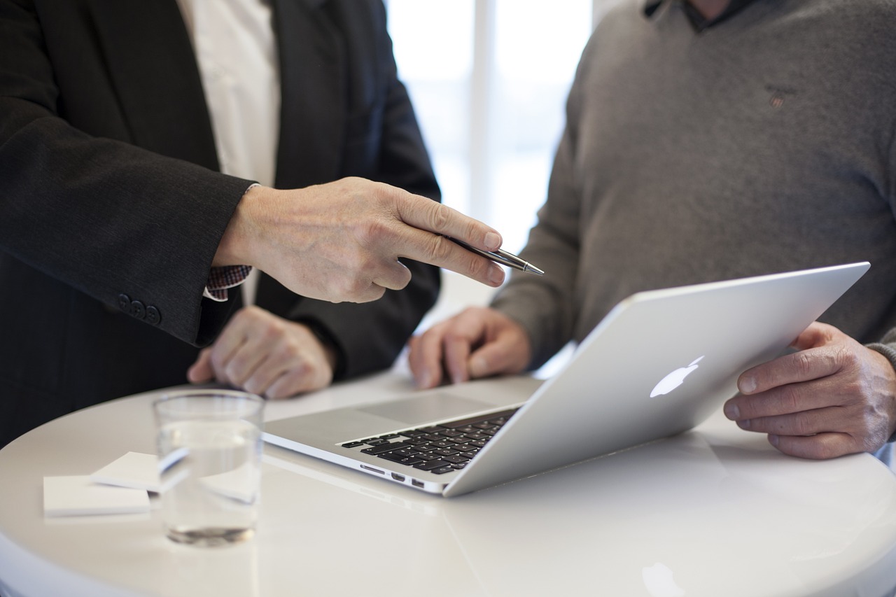 Consultor apresentando análise a um cliente em um notebook